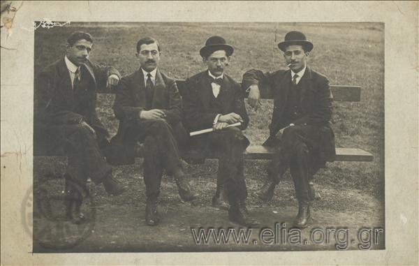Portrait of four men at a bench
