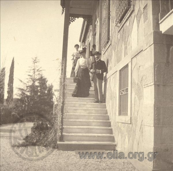 Men and women at a stairway outside a house