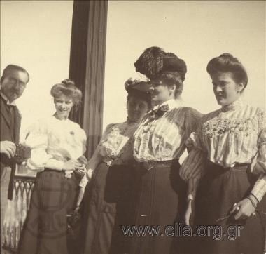 Γυναίκες και άνδρας με φωτογραφιή μηχανή σε βεράντα.