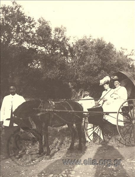 Δύο γυναίκες σε αμάξι με συνοδεία μουσουλμάνων ιπποκόμων, εκδρομή.
