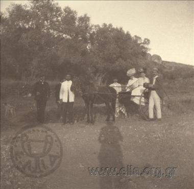 Two women on an open carriage accompanied by men and two Muslim attendants, an excursion