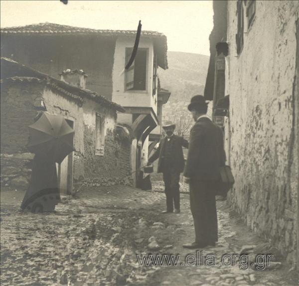 Men and a woman in a village street, outing