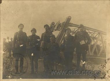 Group portrait of servicemen next to a bridge.