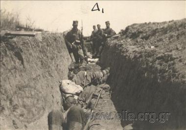 Έλληνες στρατιώτες σε βουλγαρικό χαράκωμα, μετά την κατάληψή του. Στέκονται δίπλα σε νεκρούς Βούλγαρους στρατιώτρες, μάχη του Κιλκίς, Β' Βαλκανικός Πόλεμος.