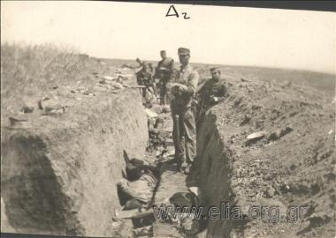 Greek soldiers standing by dead Bulgarian soldiers in a recently seized Bulgarian trench. The Battle of Kilkis, Balkan War II