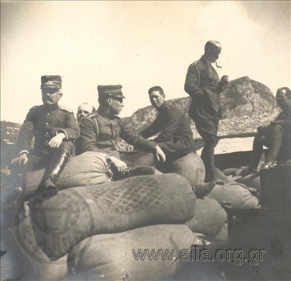 Crown Prince Konstantinos, Princes Georgios and Paul and General Panagiotis Dagklis sitting on bags at the site of Emin-Aya Inn. The Balkan Wars