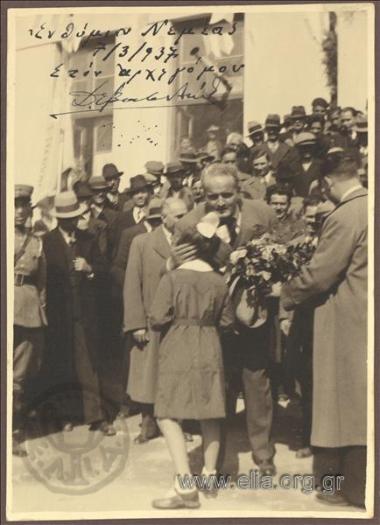 K. Kotzias with a schoolgirl offering him some flowers in a crowd of people at Nemea