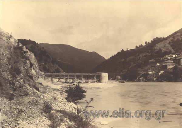 The construction of the bridge at Nestos river. A wooden frame connecting one of the banks with the main columns of the bridge. On the opposite bank, the lodgins stand out.
