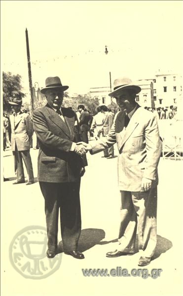 Two men in a commemorative picture shaKing hands