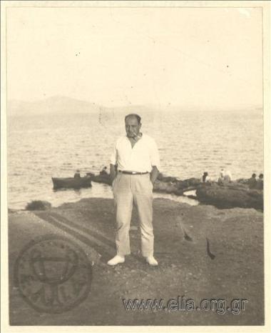 A gentleman posing in a landscape by the sea .