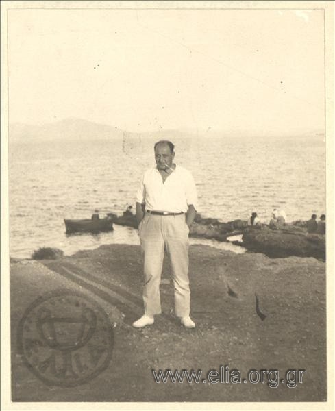 A gentleman posing in a landscape by the sea .