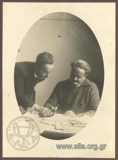 Mayor of Athens Kostas Kotzias and an associate studying some documents