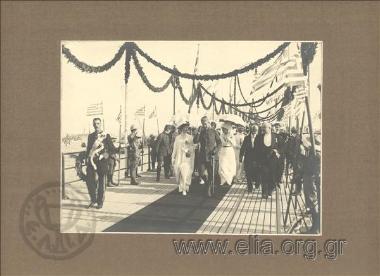 Επιστροφή του Κωνσταντίνου Α΄από το μέτωπο των Βαλκανικών. Στην υποδοχή η βασίλισσα Σοφία, ο διάδοχος Γεώργιος, η ακολουθία των βασιλέων. Δίπλα τους ο δήμαρχος Πειραιώς, Δημοσθένης Ομηρίδης Σκυλίτσης, καθώς και οι Μερκάτης και Δραγούμης.