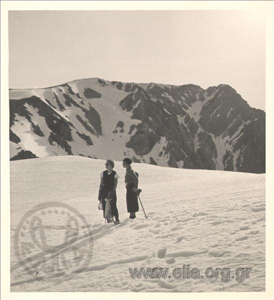 Eastern excursion. Two excursionists on a snowy slope of a mountain