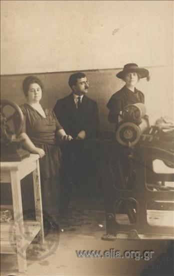 Man and two women next to printing presses