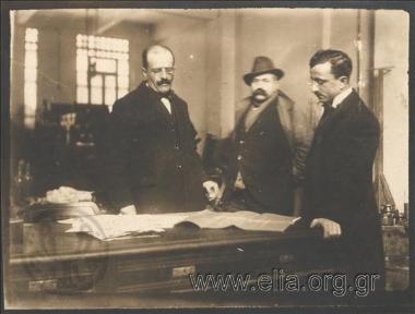 Men at a printer's studying printed matter
