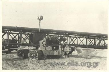 Drainage work at Lake Ioannina, reshaping of the peripheral canal around the lake: the mobile metal structure supporting the piping  for sending out muck scrapings from the lake capable of moving along the canal embankment. Dredging is carried out from ve