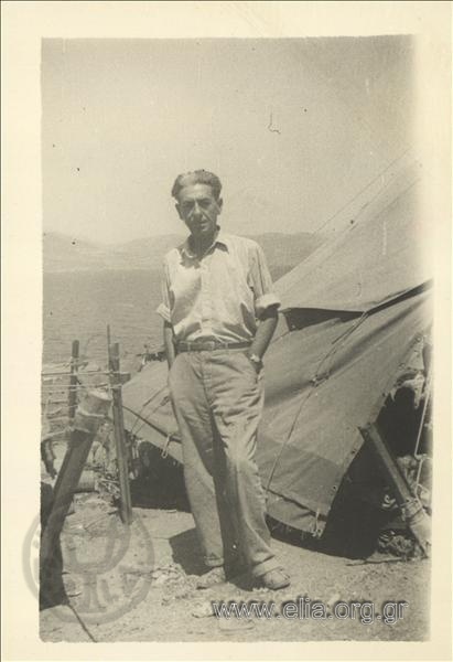 Dimitris Fotiadis outside the tent shared with 13 other exiles at a camp on the island