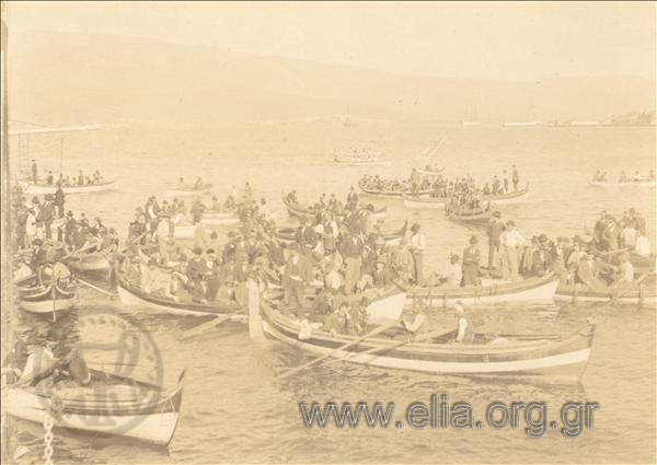 Πλήθος σε βάρκες προς προϋπάντηση ελληνικών θωρηκτών που έφτασαν στο λιμάνι της πόλης.