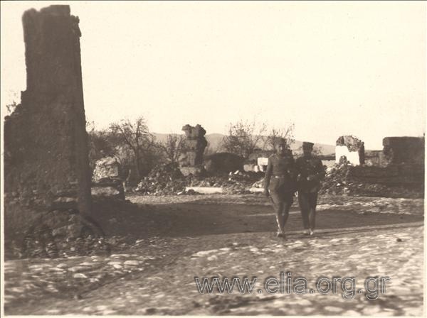 Asia Minor campaign: Greek  officers walk on a destroyed Turkish settlement.