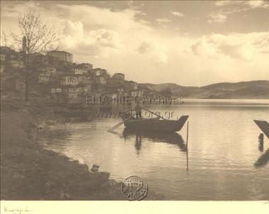 Άποψη της πόλης, σε πρώτο πλάνο ψαράς στη βάρκα του.