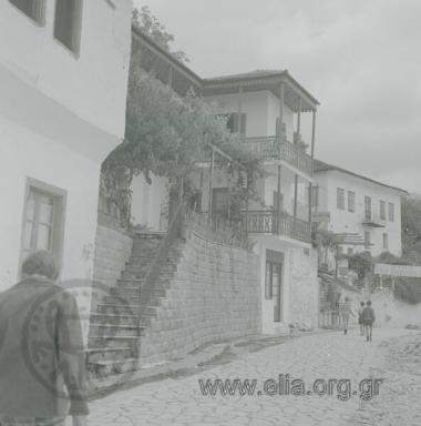 Μακρυνίτσα, φεύγωντας από την πλατεία. Αριστερά, ο ξενώνας Μαρ. Χαλβατζάκου και κατάστημα τουριστικών ειδών.