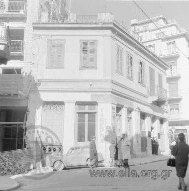 Ταβέρνα στην οδό Εμμανουήλ Μπενάκη. Στο ίδιο κτίριο το ζαχαροπλαστείο Εκάλη (στη γωνία της Εμμ. Μπενάκη με την οδό Σόλωνος). Αριστερά η οδός Γραβιάς.