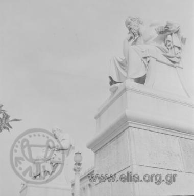 Μαρμάρινοι ανδριάντες του Πλάτωνα (αριστερά) και του Σωκράτη (δεξιά). 'Εργα του Λεωνίδα Δρόση, βρίσκονται στην πρόσοψη της Ακαδημίας Αθηνών.