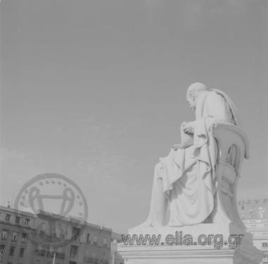 Μαρμάρινος ανδριάντας του Αδαμαντίου Κοραή. 'Εργο των Ιωάννη Κόσσου και Γεωργίου Βρούτου (πρόπλασμα και εκτέλεση, αντίστοιχα. 1873-1875). Βρίσκεται στα Προπύλαια του Πανεπιστημίου Αθηνών.