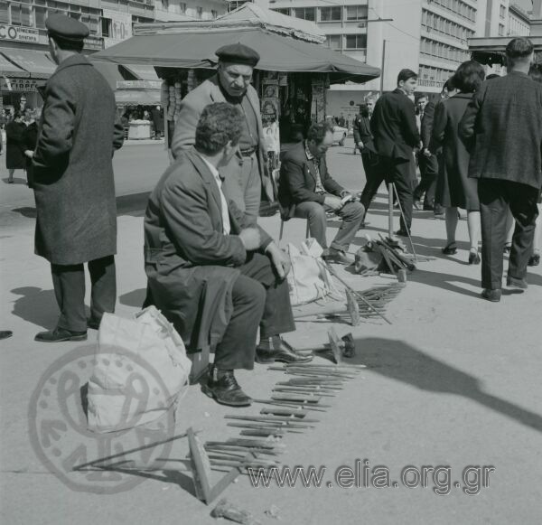 Πωλητές εργαλείων στην οδό Αθηνάς, στο ύψος της Πλατείας Κοτζιά. Στο βάθος, αριστερά, υποκατάστημα της Εμπορικής Τραπέζης της Ελλάδος.