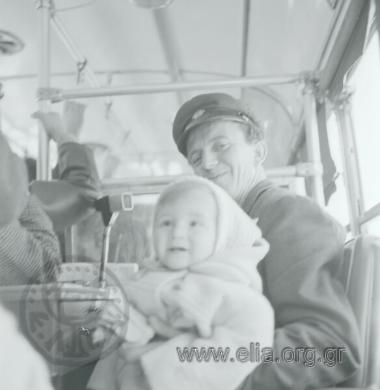 Στο αστικό λεωφορείο: ο εισπράκτορας κρατά στην αγκαλιά του παιδί.