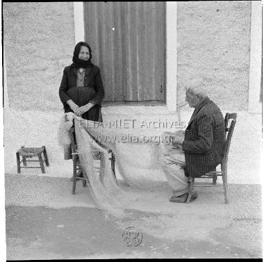 Γέροντας ψαράς μπαλώνει τα δίχτυα του.