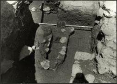 Γρόττα. Ο πρωτογεωμετρικός τάφος στα νότια του χαμηλού θρανίου στον ορθογώνιο περίβολο, μετά την αφαίρεση των καλυπτηρίων πλακών.