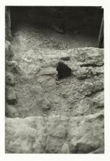 Οικία Γυναικών, Δωμάτιο 8. Τομή του (κεκλιμένου) δαπέδου του ορόφου με οπή δοκού υποστήριξης, μετά την αφαίρεση των αγγείων.