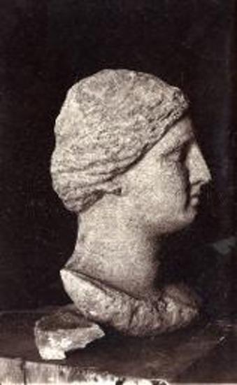 Άποψις της κεφαλής μετά λαιμού και μέρους του στήθους αγάλματος γυναικός. Παρίου μαρμάρου. Εκ φωτογραφίας γενομένης ευθύς μετά την εύρεσιν, προ του καθαρισμού. Εκ του ιερού της Πασικράτας.