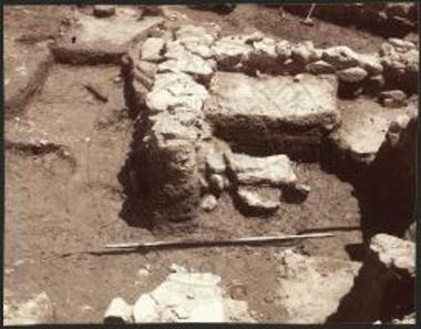 Γρόττα. Πρωτογεωμετρικός κιβωτιόσχημος τάφος προς Δ του χαμηλού θρανίου μέσα σε ταφικό περίβολο.