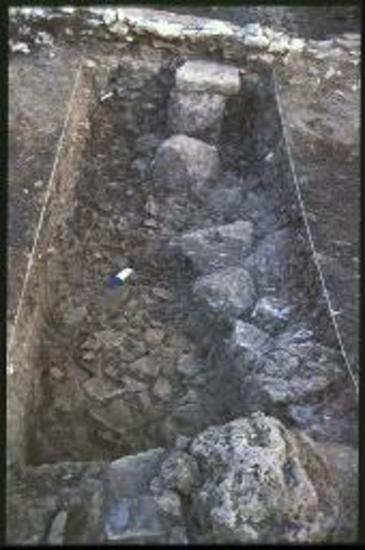 Δωδώνη. Πρυτανείο, διάδρομος της πτέρυγας Ο2 προ του δωματίου ζ'. Τομή 37 από Ν. Η ανατ. αντηρίδα στο πίσω μέρος του τοίχου Α2' '- Θ, σπόνδυλοι κιόνων και στρώμα καταστροφής.