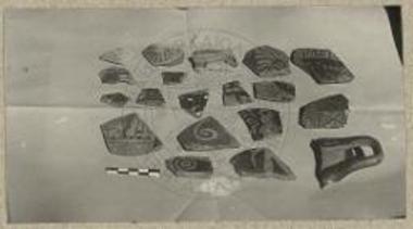 Διάφορα μελανόμορφα και ερυθρόμορφα όστρακα της σκαφής, το άνω αριστερά είναι Κορινθιακόν, το δε κάτω δεξιά λαβή κύλικος μελαμβαφούς.