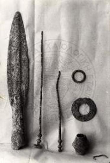 Χαλκοί κρίκοι, χαλκαί καρφίδες, χαλκή χάνδρα και αιχμή δόρατος εκ τάφου Τρουμπέ Χαλανδρίτσης.