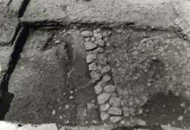 Νεολιθικός οικισμός Νέας Μάκρης. Τοίχος 5-Α. Αριστερά επίχωση με πλίνθους, δεξιά λιθόστρωτο 5-Γ με φθαρμένα τμήματα, στο κέντρο οπή 5-Γ1, επάνω δάπεδο 6ης φάσεως.