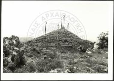 Γενική άποψη της Ψηλής Κορυφής του Γιούχτα από το βορινό πλάτωμα (Σώπατα). 1. ο χώρος της ανασκαφής (ύψ. 811 μ.) 2. ο υποσταθμός του ΟΤΕ 3. βορινή πλευρά του περιβόλου 4. η θεωρούμενη είσοδος του περιβόλου.