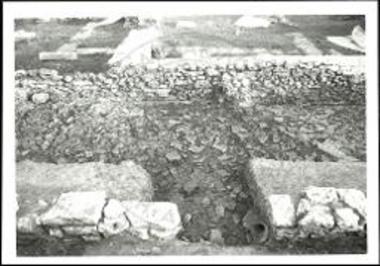 Δωδώνη. Πρυτανείο, διάδρομος της πτέρυγας Ο2 προ των δωματίων δ' και ε'. Άποψη από Ν. Η πίσω όψη του τοίχου Α2' '- Θ και το στρώμα καταστροφής.