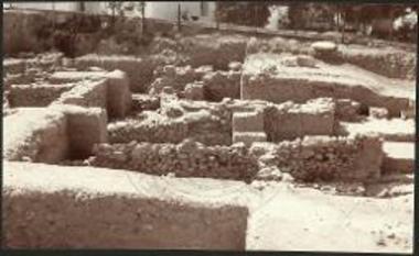 Πλατεία Μητροπόλεως Νάξου. Μπροστά ο πρόχειρος τοίχος 9 και οι μυκηναϊκές εγκαταστάσεις (δεξιά). Πίσω οι διάφορες φάσεις των γεωμετρικών κατασκευών. Στο κέντρο αριστερά στον μάρτυρα, διακρίνεται καλά ο παλαιότερος τοίχος 49 κάτω, η ΒΑ γωνία των τοίχων 31 και 46 επάνω του και λίγο πιο κάτω η προσθήκη του τοίχου 5.