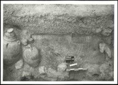 Φρέαρ 39. Η ανώτερη στρωματογραφία του σκάμματος με αγγεία τοποθετημένα επάνω στα διευθετημένα μπάζα της καταστροφής.