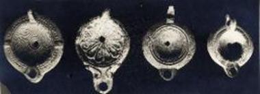 Τέσσαρες λύχνοι μετά συμπαγούς λαβής εκ του ρωμαϊκού νεκροταφείου.