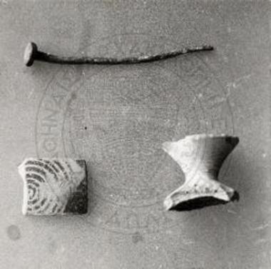 Θραύσματα πρωτογεωμετρικών αγγείων και σιδηρούς ήλος εκ του γεωμετρικού κτίσματος.