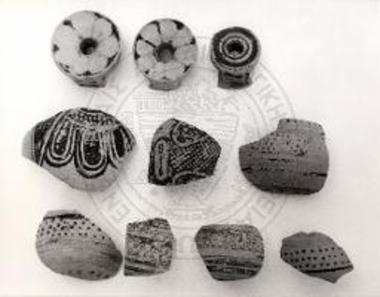 Η στεφάνη τριών σφαιρικών αρυβάλλων και όστρακα από τον κορμό των ίδιων ή και άλλων, του τάφου ΚΚ/34.