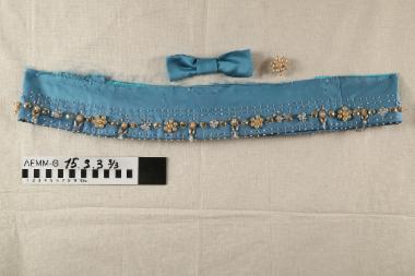 Τμήμα υφάσματος - τμήμα υφάσματος (ποδόγυρος) σατέν ντουσέζ τιρκουάζ, μακρόστενο, κεντημένο με χάντρες πλαστικές ασημί και κρυσταλλοειδείς, πέρλες πλαστικές εκρού και λευκές και πούλιες πλαστικές ασημί. Κομμένο από φόρεμα