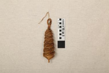 Στολίδι ψάθινο - διακοσμητικό αντικείμενο από πλεγμένη ψάθα σε ατρακτοειδές σχήμα, με θηλιά ανάρτησης στο άνω άκρο