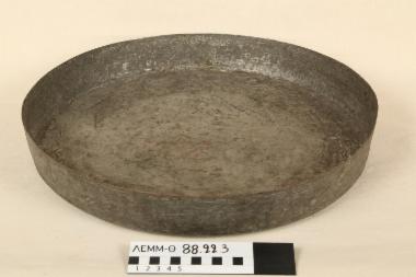 Ταψί - σκεύος χάλκινο σφυρήλατο, γανωμένο, κυκλικού σχήματος, πλατύ με μέτριο βάθος και κάθετα τοιχώματα. Φέρει διακόσμηση 